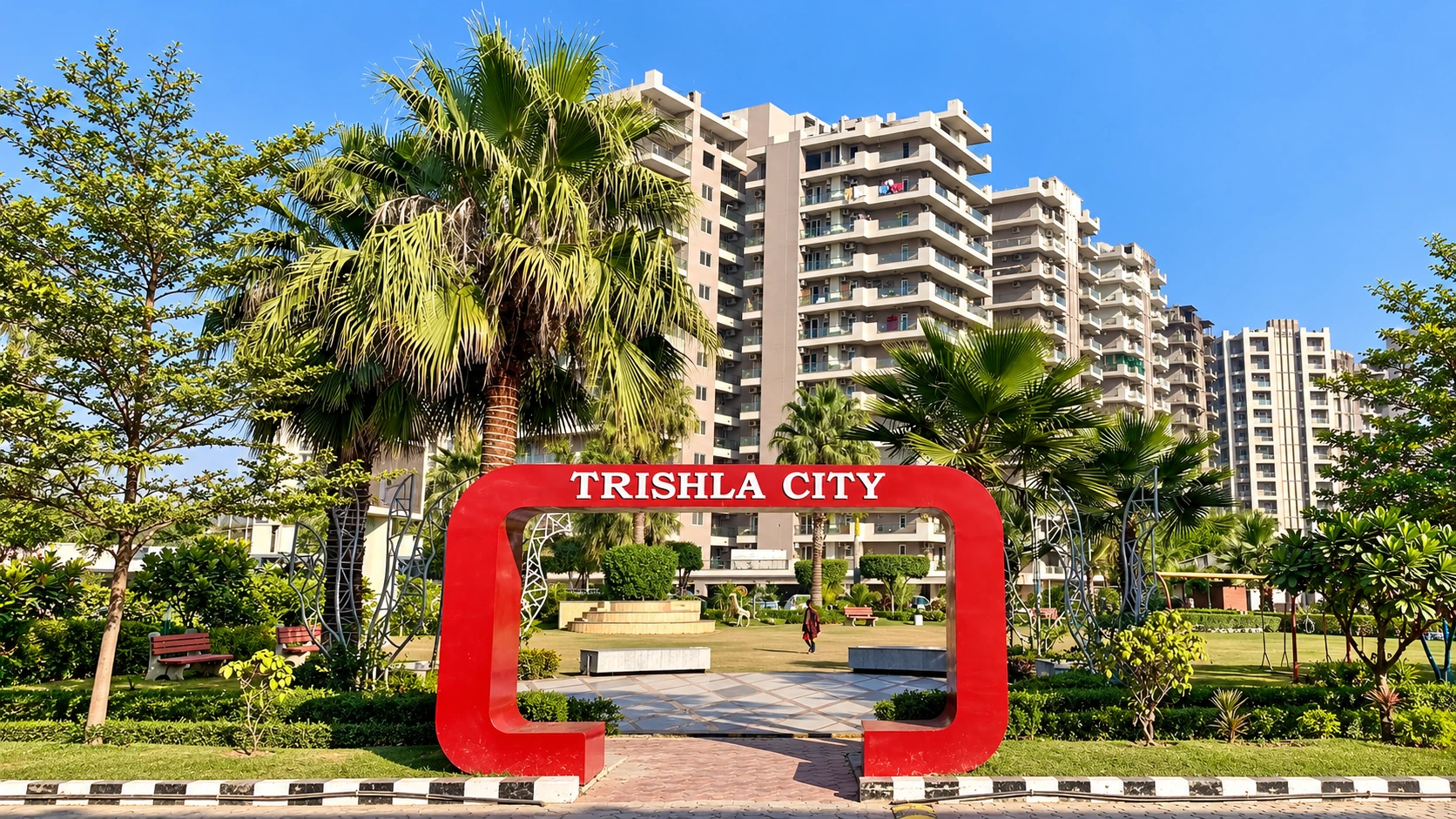 Red Trishla City arch on the landscaped plaza with residential towers behind